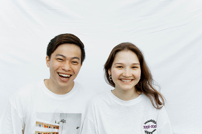 Smiling couple posing together against a white background, representing a wife obsessed with looking like an Asian child.