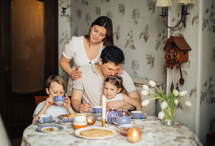 Family having breakfast together, highlighting wife and kids affected by husband's passport affordability issue.
